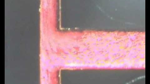 Microfluidic mixing under low frequency vibration - swirling of particle laden fluid