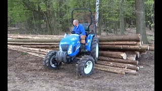 Traktor NEW HOLLAND Boomer 50 - nahrnování klád na hromadu u lesa