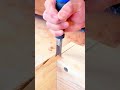 Shaping the corner joint of a wooden box structure using a sharp hand chisel tool with precision