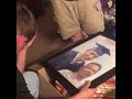 A man revealing a painting of himself and his father