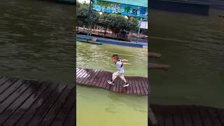 A cute 3-year-old kid challenges himself to float on the water. His grandmother encourages
