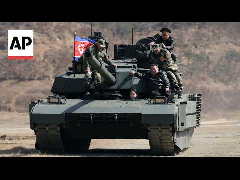 North Korean leader sits on tank with his daughter at military exercise