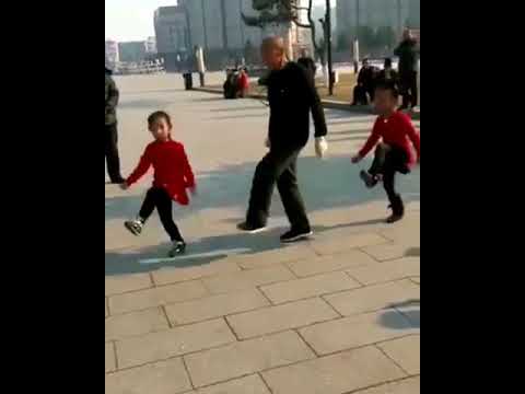 Chinese grandpa and two girls shuffle dance