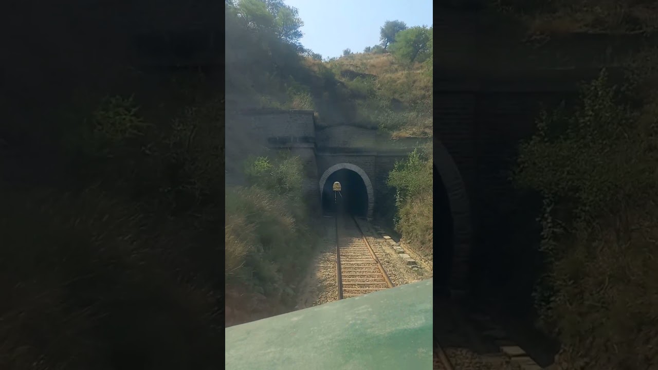 Live view from cab of fastest train crossing through tunnel in mountains countryside 