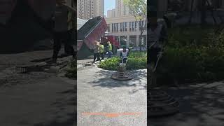 Skilled Worker Operating Concrete Trowel Machine at Road Construction Site