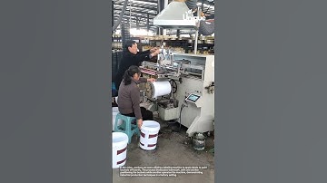 Labeling machine to apply labels to paint buckets