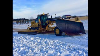 CAT140M PLOWING SNOW