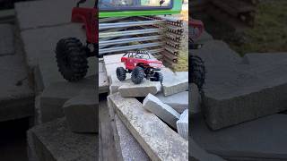Axial SCX24 Deadbolt crawls over some stone