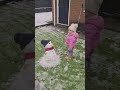 Baby kissing her first snowman 