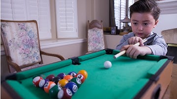 6 Year-old billiard prodigy playing with a mini pool table