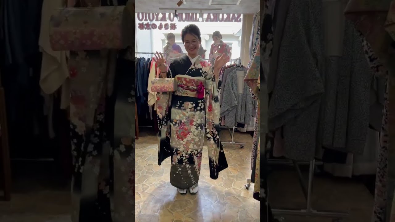 The cherry blossoms on black are elegant, and the coordination with the obi and bag is stunning.