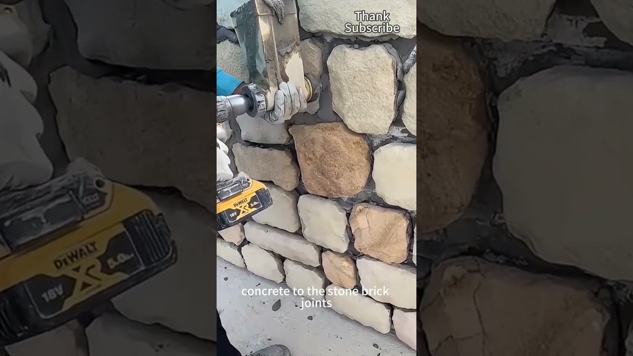 Workers use grouting machine to apply concrete to the joints between stone bricks