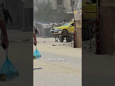 رجل من القطاع يحمل سيارته على عربة تجر ها داب ة