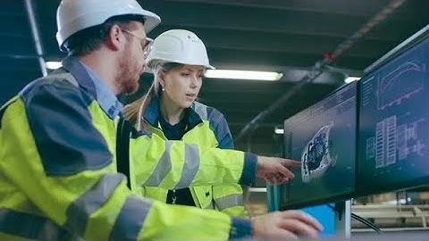 Inside Factory Male Mechanical Engineer and Female Chief Engineer Work Together on the PC | Stock