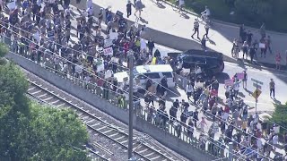 Raw: Protesters march down Forest Park Parkway in Clayton