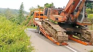 The process of raising and lowering a Hitachi excavator from a self-loader truck "