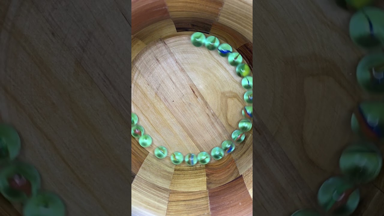 Marbles rolling in a wooden pot 