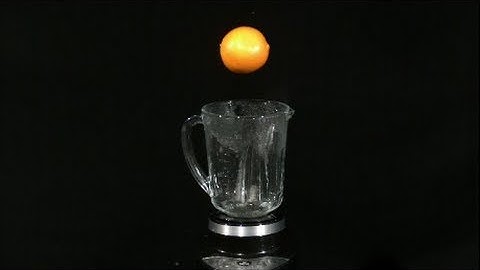 Blending an Orange Slow Motion into a Blender in High Definition HD Slow Mo Video Camera Action Shot