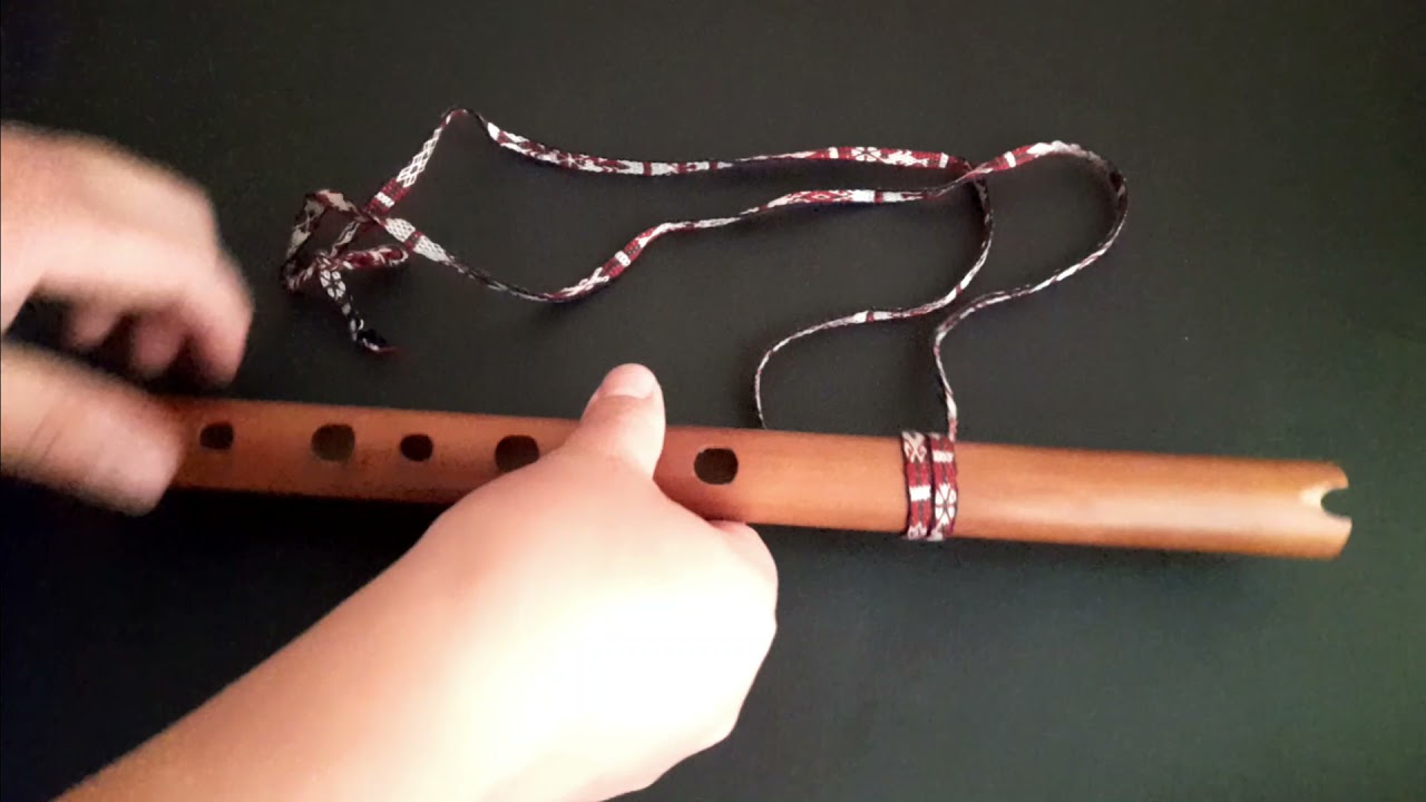 Amarrando una cinta para colgar la Quena