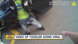 Video: Toddler walks with her hands up toward police officer