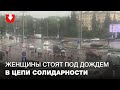 Женщины стоят под дождем в цепи солидарности