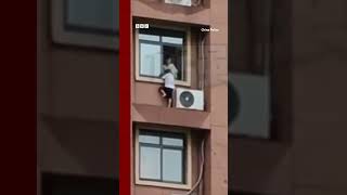 Child plays on high-rise window ledge in China. #Shorts #China #BBCNews