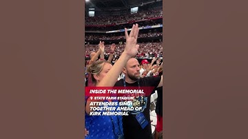Attendees sing together at the Charlie Kirk memorial