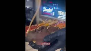 Guy standing on bike squirts cheese on food