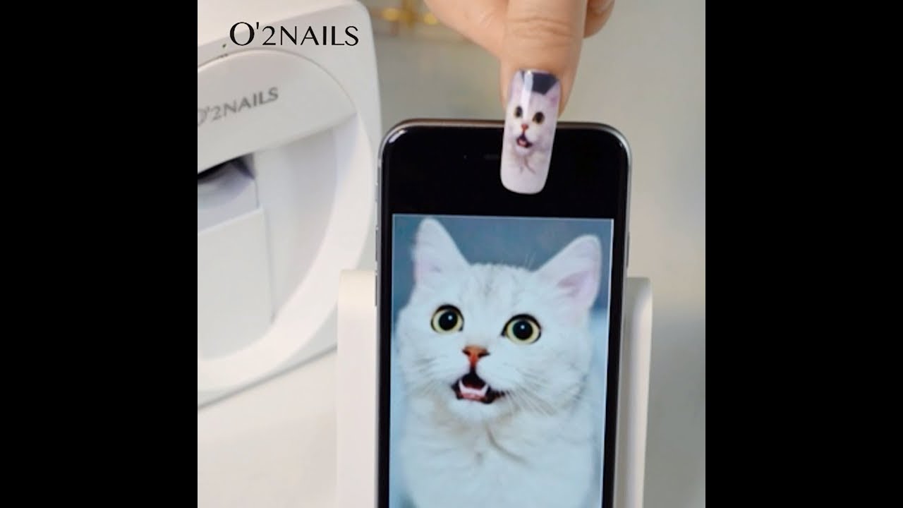 Nail printer printing a custom cat design directly onto a natural nail