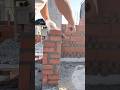 Worker laying bricks applying mortar with hand trowel construction
