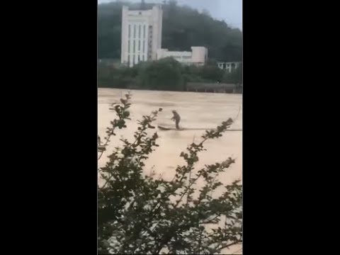 Man drifting in torrent in Fujian, China