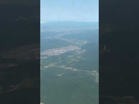 夏の夕張山地 芦別市街の谷地の上空を越えていくAIRDO-B767機内窓からの景色