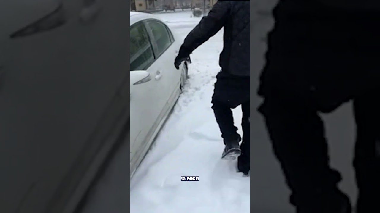 Reporter, photographer helps person push their car through the snow