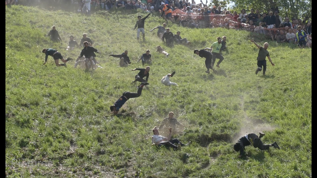 Please enjoy this clip of British people chasing cheese down a