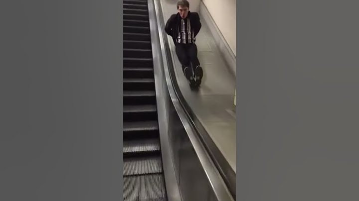 Man sliding down escalator and hitting speed bumps.