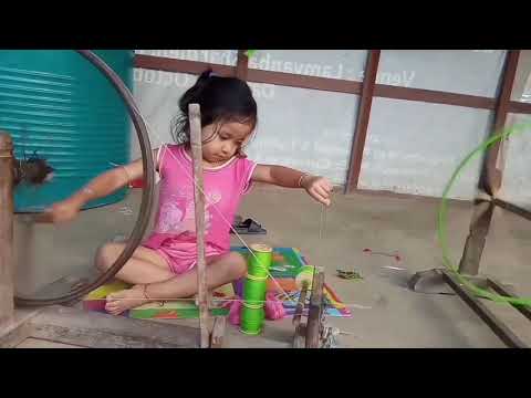 CHILD WITH SPINNING WHEEL: Learning by observing, cute, devoted, little pure heart, little skills.