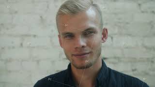 Slow motion portrait of handsome blond man standing outdoors in city with stone walls in background