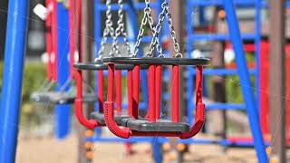 Slow motion of swings at empty children playground in residential area of Chisinau, Moldova during