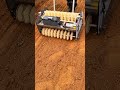 operating an electric soil tiller and leveler machine on a brown dirt field outdoors on a farm