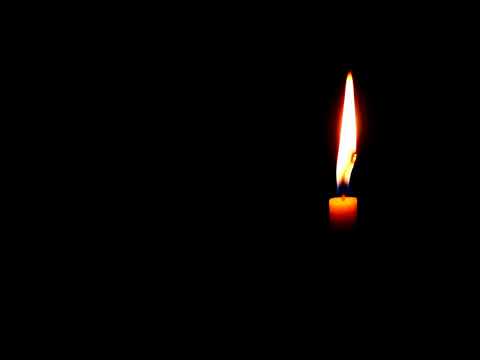 A single candle burning in the dark