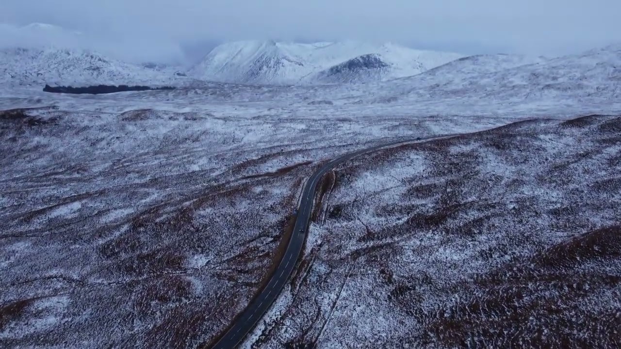 ❄️🛣️ 4K Aerial View: Road Cutting Through Vast Snowy Landscape 🚁❄️