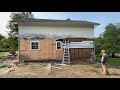 Removing old wood siding on a 1840 house with brick insulation.