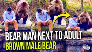 Bear Man Talking To Adult Brown Male Bear and Feeding Him Treats