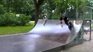 Razoor on rollerblades on halfpipe with spine
