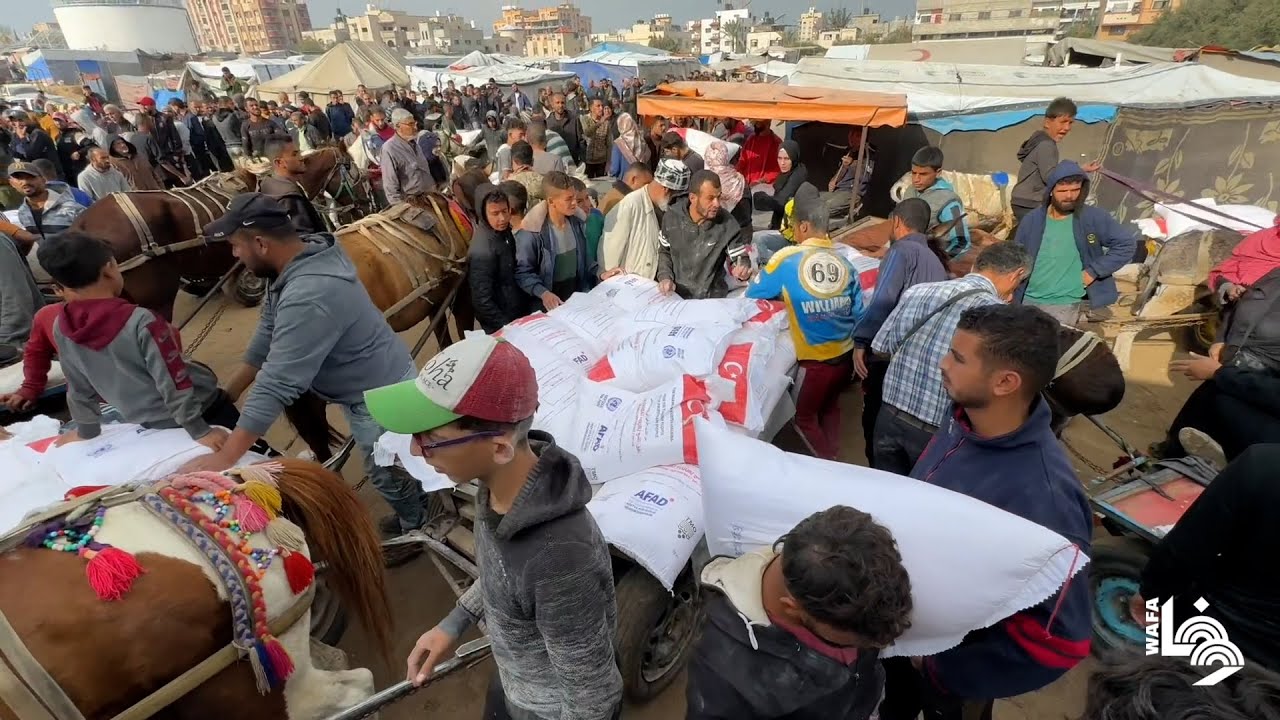 نازحون يتجمعون للحصول على الطحين من وكالة غوث 