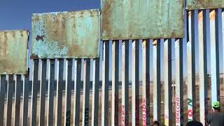 Un integrante de la caravana trata de escalar la valla con EEUU