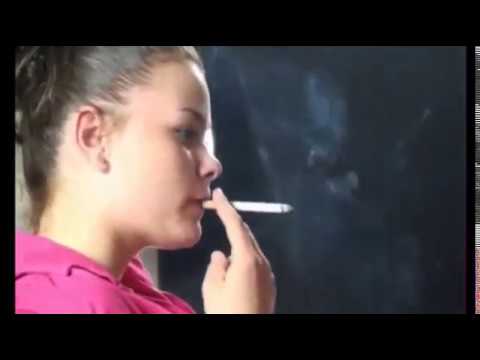 Young brunette smokes a long cigarette