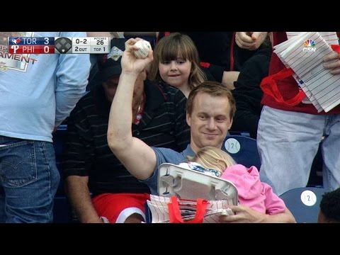 Fan grabs foul ball while holding his child