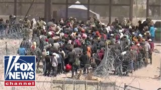 WATCH: Hundreds of migrants breach razor and rush the US border