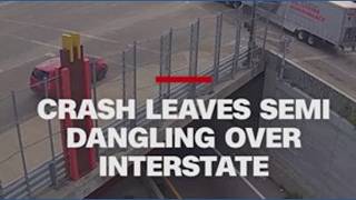 Crash leaves semi dangling from overpass